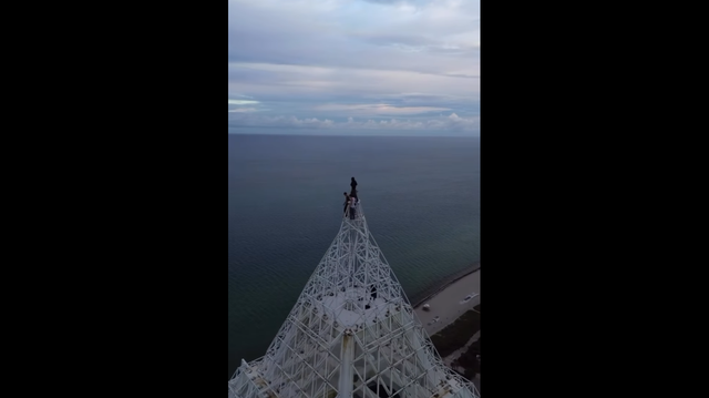 A screenshot of an Instagram post showing people climbing the Blue and Green Diamond condo tower in Miami Beach.